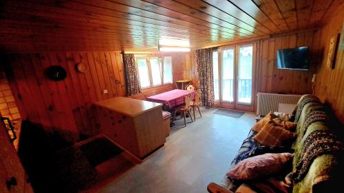 una sala de estar con un sofá y una mesa en FREE Bus Winter Haus Ramona, en Saas-Grund