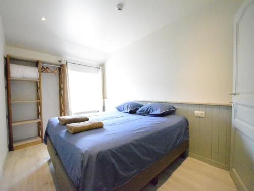 a bedroom with a bed with blue sheets and a window at Riverside Villa in Bouillon in Bouillon