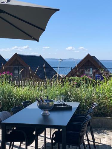 a blue table with chairs and an umbrella at Haabakk on Sea in Tau