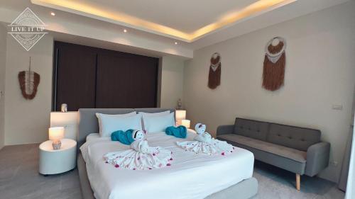 a bedroom with a large bed with two dolls on it at Santi Tara Villas in Amphoe Koh Samui
