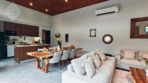a living room with a dining table and a kitchen at Santi Tara Villas in Amphoe Koh Samui