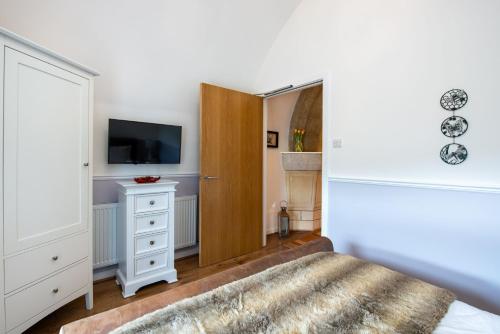 a bedroom with a bed and a tv and a dresser at The Highland Club in Fort Augustus