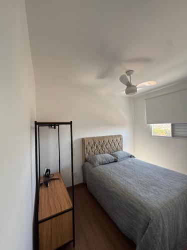 a bedroom with a bed and a ceiling fan at Apartamento em Barretos in Barretos