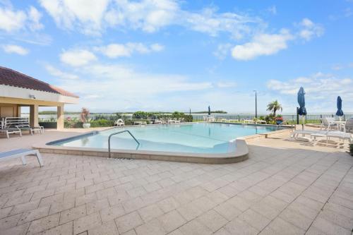 a large swimming pool with tables and chairs at Breath-taking waterfront condo with pool/spa/tennis in Marco Island