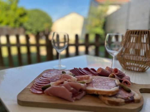 a plate of cured meats and wine glasses on a table at Charmant studio à 10 min de Lyon in Miribel
