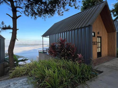 a house with a metal roof with a view of the ocean at ร่มการเวก เขาค้อ ROM KARAVEK Khao Kho Resort in Khao Kho