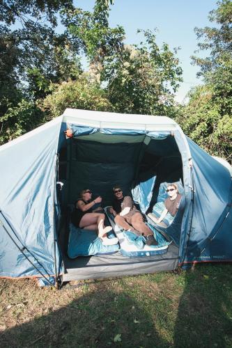 three men are laying in a tent at Løst Souls Oktoberfest Campsite in Munich