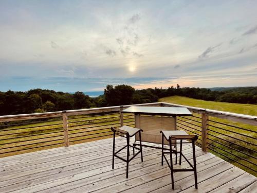 a table and two chairs on a wooden deck at Barn On The Ridge - HOT TUB - Sleeps 6 in De Soto