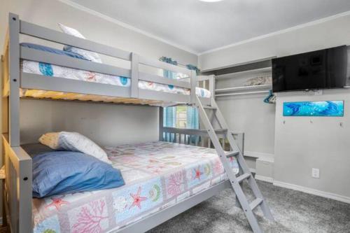 a bedroom with a bunk bed with a ladder at 3 Bedroom Gulfport Rental by Next Step Property Management in Gulfport