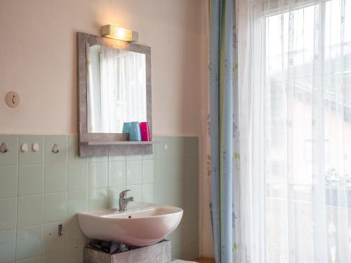 a bathroom with a sink and a mirror and a window at Apartment in Tröpolach near Ski Lift in Tröpolach