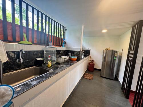 a kitchen with a sink and a stainless steel refrigerator at Marari Helen Villa in Mararikulam
