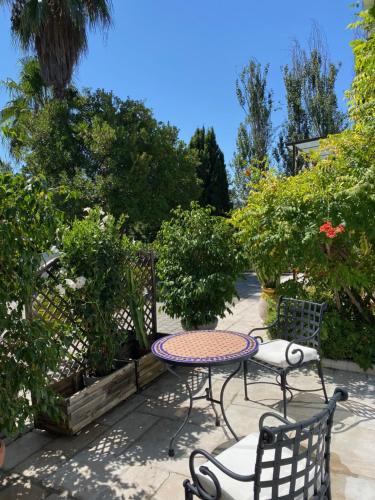 a patio with a table and chairs and trees at Chambre de charme climatisée, avec piscine in Grasse