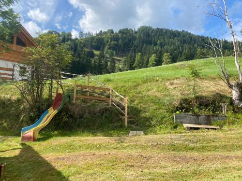 a playground with a slide in a field at Haus Bergliebe in Winkl Reichenau