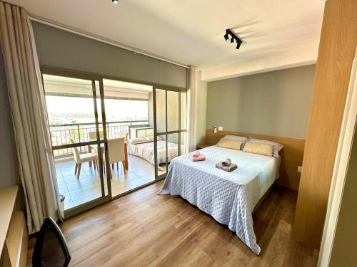 a bedroom with a bed and a balcony at Studio no centro de Guarulhos a 7km do aeroporto in Guarulhos