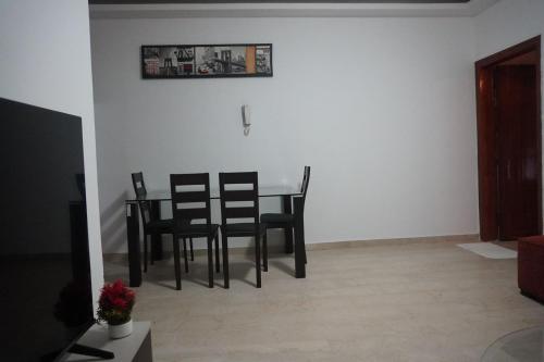 un tavolo da pranzo e sedie in un soggiorno di Les muguets de chaville a Abidjan