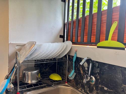 a dish drying rack next to a sink with dishes at Marari Helen Villa in Mararikulam