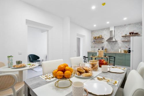 a kitchen with a table with a bowl of oranges at Vintage Senses Residences in Faro