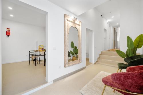 a living room with a red chair and a mirror at Vintage Senses Residences in Faro