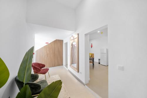 a hallway with a red chair and plants at Vintage Senses Residences in Faro