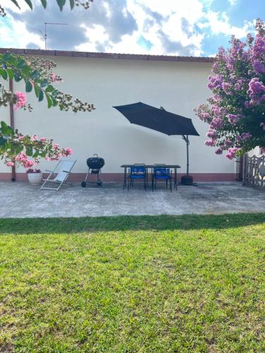 a patio with a table and a grill and an umbrella at Il Tulipano - Villa con giardino in Bionde di Visegna