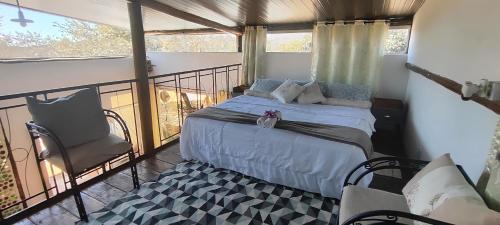 a bedroom with a bed and a balcony at Chalés sol e luar in Serra do Cipo