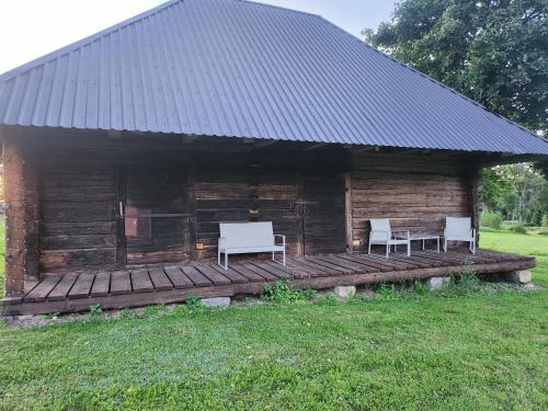 a log cabin with two white chairs on a deck at Talu villa 