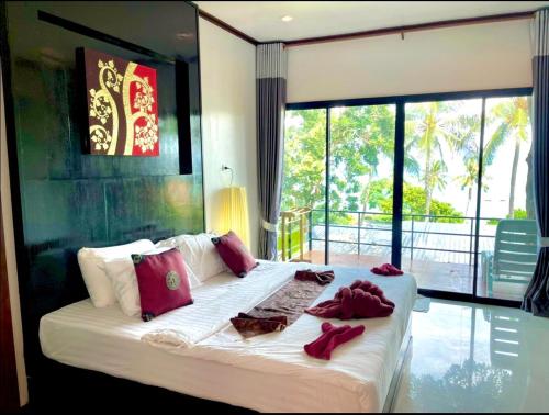 ein Schlafzimmer mit einem großen weißen Bett mit roten Kissen in der Unterkunft Kathalee Beach Resort & Spa in Ko Lipe