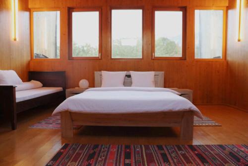 a bedroom with a large bed and windows at Centrul 3H in Sub Piatra