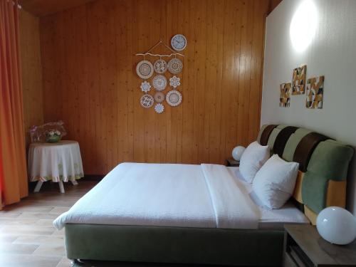 a bedroom with a bed and a wooden wall at Centrul 3H in Sub Piatra