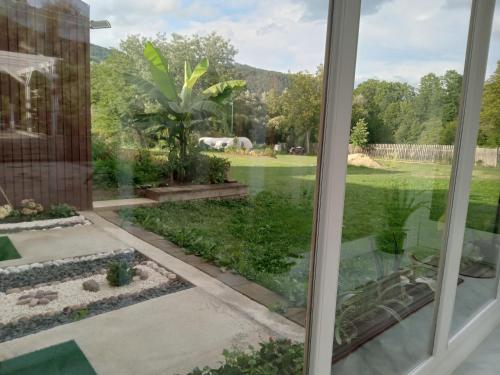 a view of a garden from a window at Centrul 3H in Sub Piatra