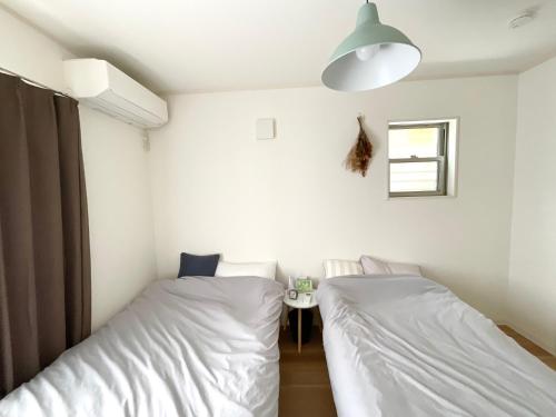 Ένα ή περισσότερα κρεβάτια σε δωμάτιο στο marui home hibino guesthouse