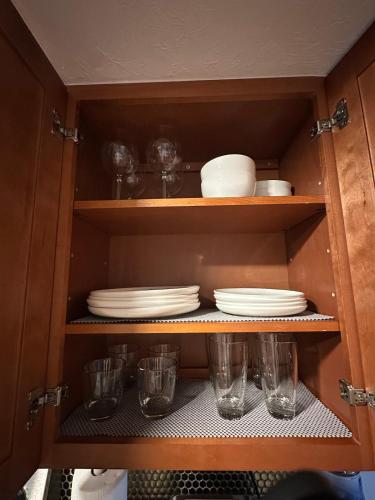 a cupboard with plates and glasses in it at Deland Serenity Place #1 in DeLand