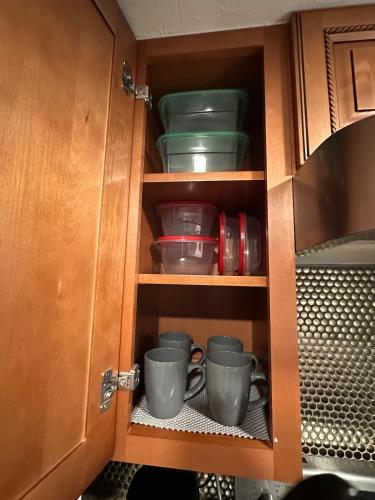 a cupboard with some cups and dishes in it at Deland Serenity Place #1 in DeLand