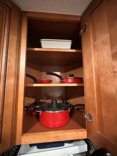 two red pots and pans in a kitchen cabinet at Deland Serenity Place #1 in DeLand