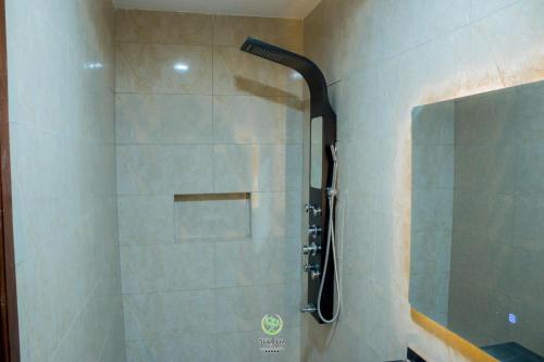 a shower with a glass door in a bathroom at Maghaz Royal Hotel in Tamale