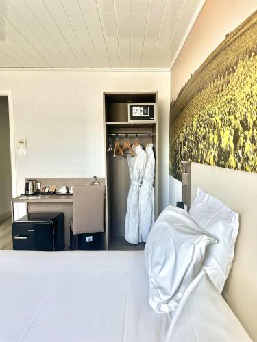 a bedroom with a bed and two white dresses in a room at Best Western Hotel Ile de France in Château-Thierry
