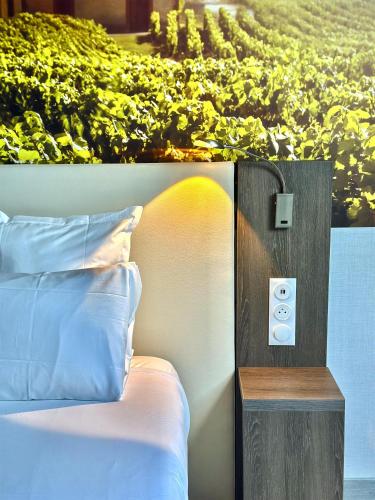 a bed in front of a painting of a vineyard at Best Western Hotel Ile de France in Château-Thierry