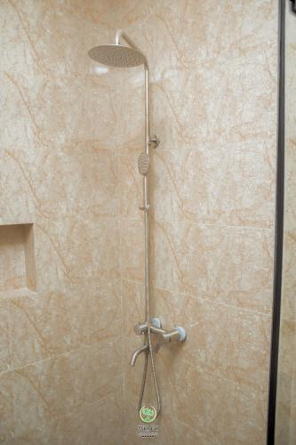 a shower with a shower head in a bathroom at Maghaz Royal Hotel in Tamale