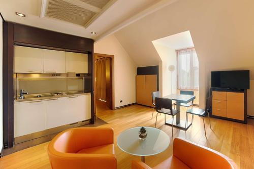 a living room with orange chairs and a table at NH Milano 2 Residence in Segrate