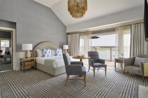 a bedroom with a bed and a table and chairs at Wequassett Resort and Golf Club in East Harwich