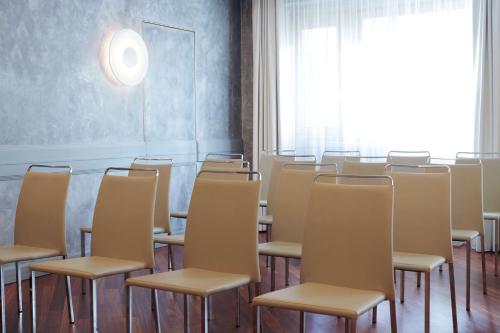 an empty room with chairs and a large window at NH Milano 2 Residence in Segrate
