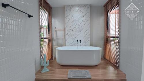 a bathroom with a white tub in a room at Santi Tara Villas in Amphoe Koh Samui