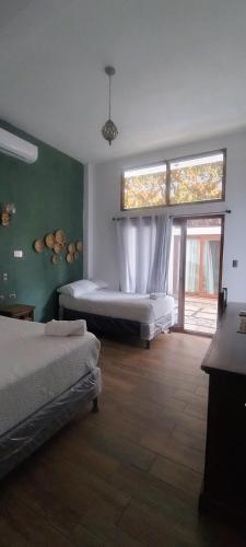 a bedroom with two beds and a large window at MAYAN SURF HOTEL in El Paredón Buena Vista