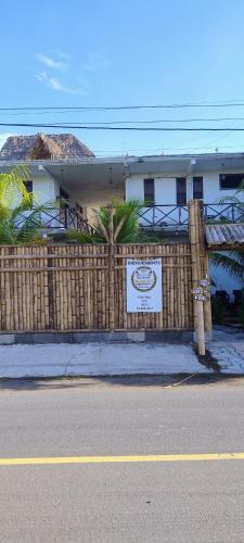 a fence in front of a house with a sign at MAYAN SURF HOTEL in El Paredón Buena Vista