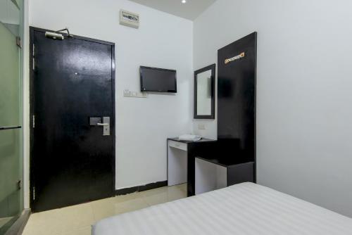 Habitación con cama y puerta negra en Hotel Pavilion Port, en Pelabuhan Kelang