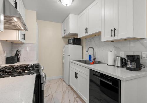 a kitchen with white cabinets and a white refrigerator at Cozy&Stylish DT Alhambra Living walk to Starbucks in Alhambra