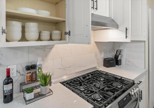 a kitchen with a stove and white cabinets at Cozy&Stylish DT Alhambra Living walk to Starbucks in Alhambra
