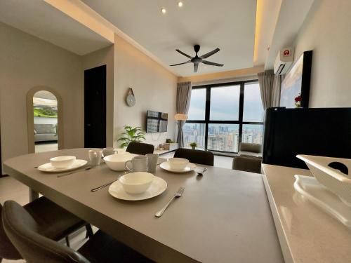 a dining room table with chairs and a ceiling fan at Cozy Urban Suites Georgetown View in Jelutong