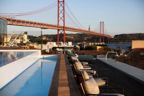 a pool on the roof of a building with a bridge at MACAM Hotel in Lisbon