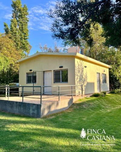 a small yellow building with a grass yard at Cabañas Finca Casiana in Santa Lucía
